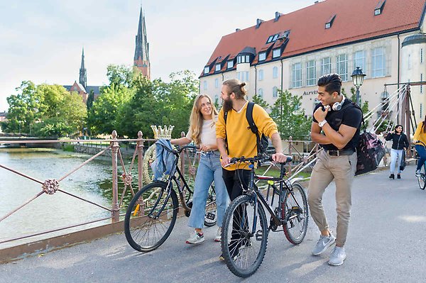 Tre studenter som samtalar medan de promenerar över Järnbron i Uppsala centrum.