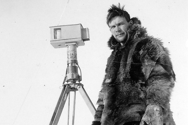 Finn Malmgren stands outdoors in thick fur clothing by a measuring instrument