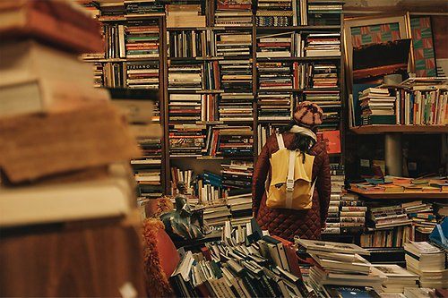 Woman with backpack looking at books in a book store