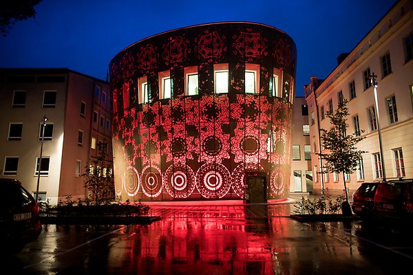 The outside of the humanistic theater lit up with red light in the evening