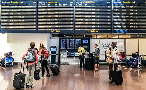 Passengers looking at departure information board at Arlanda airport