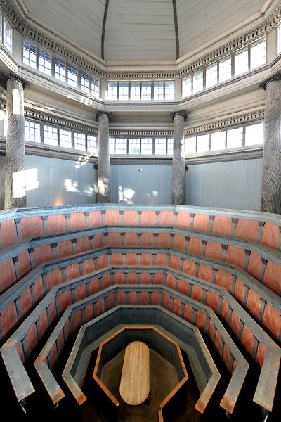 Anatomiska teatern med rader av bänkar runt och ovanför ett obduktionsbord och fönster runtomkring